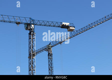 Les grues de construction sur fond de ciel bleu clair Banque D'Images