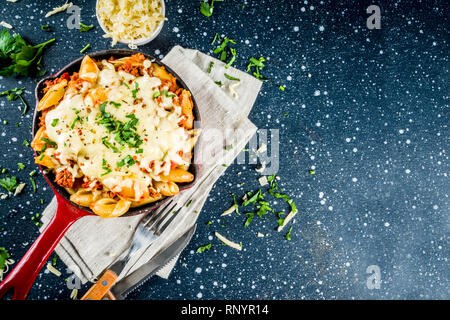 Casserole de Pâtes crémeuses au four, macaroni au fromage avec de la viande hachée, sol italien boeuf bolognaise en cocotte, bleu foncé fond béton copy space Banque D'Images