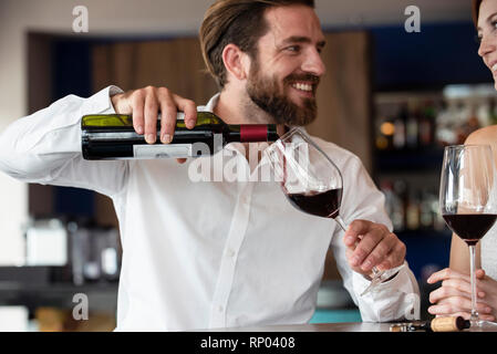 Mid adult man pouring red wine in glass Banque D'Images