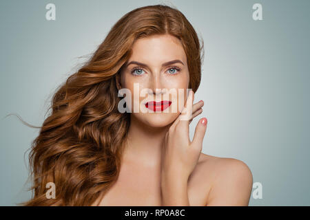 Femme aux cheveux rouge parfait. Jeune fille rousse élégante avec curly hairstyle. Smiling woman portrait Banque D'Images