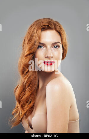 Jeune fille rousse d'offres avec la peau de taches de rousseur en bonne santé. Caucasian woman modèle avec cheveux gingembre posant à l'intérieur Banque D'Images