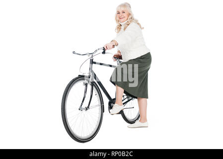 Cheerful senior woman riding bicycle isolated on white Banque D'Images