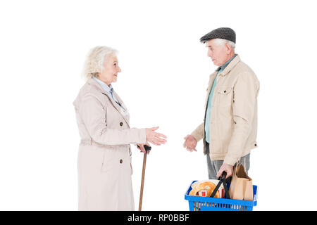 Senior woman looking at husband holding panier isolated on white Banque D'Images