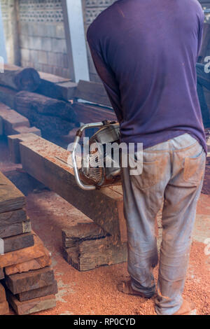 Carpenter est l'utilisation de moteur à essence, Tronçonneuse portative couper du bois. Banque D'Images