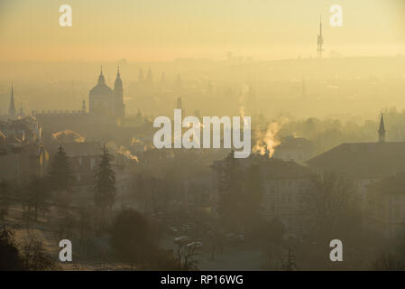 Matin d'hiver dans la partie historique de Malá Strana de Prague, République tchèque. Église Saint Nicolas. Le lever du soleil. Le brouillard. Vue depuis le monastère de Strahov. Banque D'Images