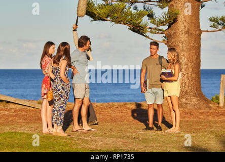 Acteurs et un bon Perchman de filmer une scène en plein air de l'accueil et à l'écart du programme de télévision au Palm Beach, New South Wales, Australie Banque D'Images