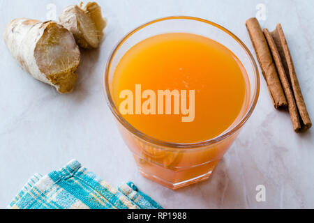 Boisson asiatique saine Jamu avec le curcuma et le bâton de cannelle, le jus d'Orange. Boisson traditionnelle. Banque D'Images