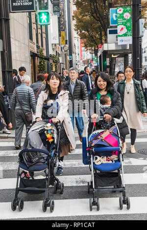 Le Japon, Honshu, Tokyo, Ginza, deux jeunes mères poussant des landaus et portant des bébés Banque D'Images