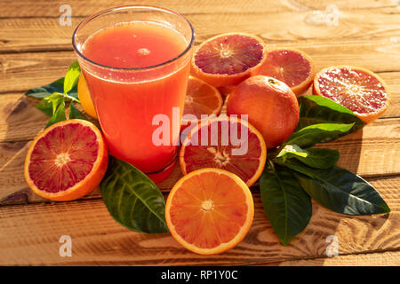 Le verre avec du jus d'Orange d'Orange Sanguine avec fruits frais. Tourné en extérieur au soleil Banque D'Images