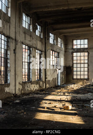 L'intérieur d'un vieux bâtiment abandonné allégé par le bris de fenêtres Banque D'Images