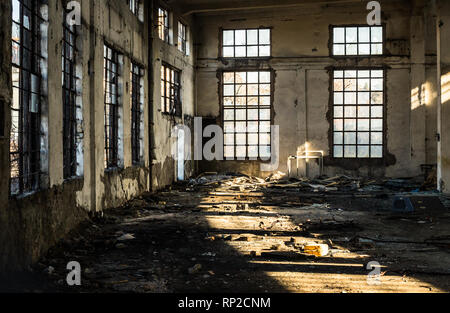L'intérieur d'un vieux bâtiment abandonné allégé par le bris de fenêtres Banque D'Images
