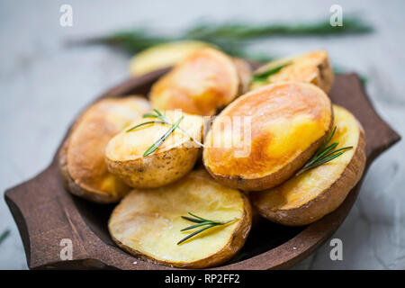 Pommes de terre rôties au romarin herbe dans bol en bois, les pommes de terre fraîchement cuits savoureux Banque D'Images