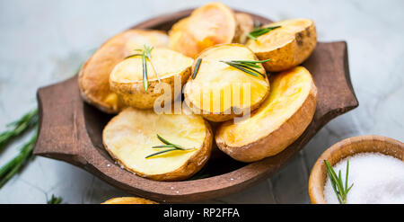 Pommes de terre rôties au romarin herbe dans bol en bois, les pommes de terre fraîchement cuits savoureux Banque D'Images