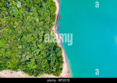 (Vue de dessus) Superbe vue aérienne d'une une côte verte d'une île tropicale, avec quelques bateaux de pêche traditionnelle dans le réservoir de la Nam Ngum. Banque D'Images