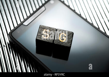 Lettres avec l'étiquette 5 g de mentir sur un Smartphone, 5G-net, Buchstabenwürfel mit der Aufschrift 5G liegen auf einem Smartphone, 5G-Netz Banque D'Images