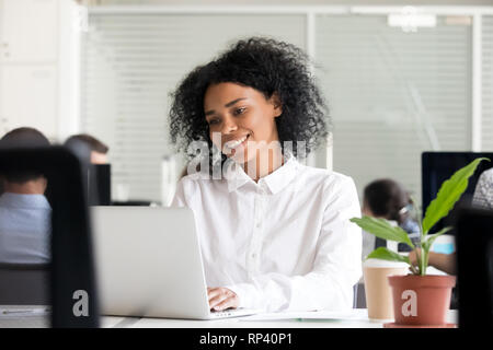 Divers collaborateurs office mixed race noire africaine happy female travaillant à l'espace coworking agréable à lire message compu Banque D'Images