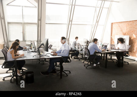 Divers travailleurs multiraciale sitting at desk travaillant en espace de coworking. Occupé à six collaborateurs d'affaires à l'aide d'ordinateurs tapant chat problèmes busi Banque D'Images