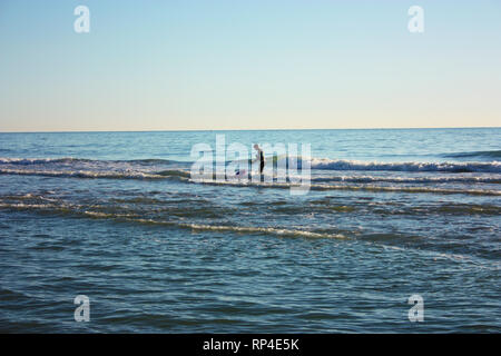 L'homme plongé dans la mer et pêche recueille des tellines ou palourdes ou d'autres fruits de mer sur une journée d'hiver Banque D'Images
