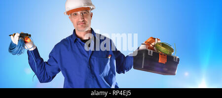 Électricien en uniforme en salopette bleue et protections de sécurité et des outils sur fond dégradé bleu avec des lumières isolées. Vue de face. Banque D'Images