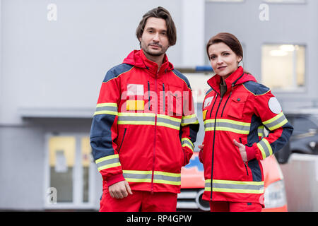 Paramédics en uniforme rouge debout sur rue et looking at camera Banque D'Images