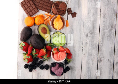 Jeu de boules de glace de différentes couleurs et saveurs de petits fruits, de chocolat et de fruits sur une table Banque D'Images