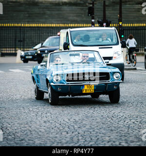 PARIS, FRANCE - 21 MAI 2016 : Couple in vintage Mustang roulant détendu sur la rue Paris coblestone Banque D'Images