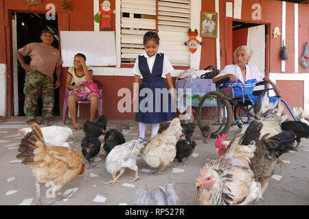 Nicaragua CANTERA projets. Accueil de José Sanches (63), son épouse Melonia Ayala (60), tante Pétronille Ayala (96), filles Marciel et petite fille Naomi (6). L'alimentation des poules. Naomi Banque D'Images