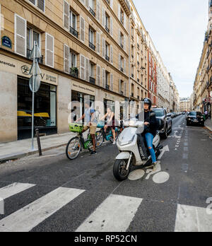 PARIS, FRANCE - OCT 13, 2018 : Femme en scooter et vélos en attendant le feu vert à l'intersection à Paris Banque D'Images