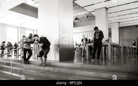 Barcelone, Espagne - circa 2018 : Les gens de l'emblématique Apple Store dans le centre de Barcelone à l'aide nouveau iphone Xs et les ordinateurs portables Apple MacBook Pro de l'avenue Passeig de Gracia - noir et blanc Banque D'Images