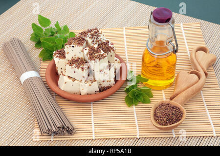 Vegan aliments de santé au tofu caillé saupoudrés de graines de luzerne et de poivre, d'huile d'olive, l'origan herb & nouilles soba. Banque D'Images