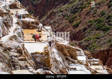 Les travailleurs des mines de sel de Maras sur la colline, dans la région montagneuse du Pérou Cuzco. Banque D'Images