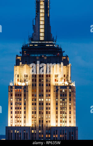 Haut de l'Empire State Building illuminé au crépuscule sur ciel bleu foncé Banque D'Images
