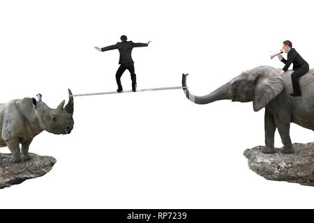 Un homme à cheval contre l'éléphant avec un autre homme rhinocéros corde d'équilibrage sur deux falaises, isolé sur fond blanc. Banque D'Images