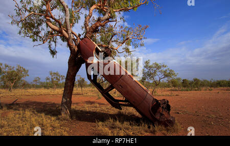 Rusty abandonné voiture accidentée contre un arbre le long d'une route à distance dans l'outback du Queensland. Banque D'Images