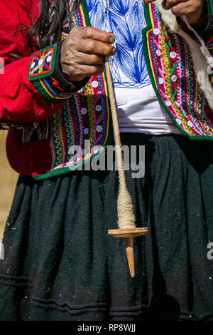 Femme en costume traditionnel fil de laine Alpaga tourne sur le tiroir à Vallée sacrée, région de Cuzco, Pérou. Banque D'Images