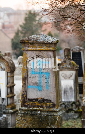 Tombes anciennes vandalisé avec des symboles nazis en bleu peint sur les tombes endommagées - cimetière juif à Quatzenheim près de Strasbourg Banque D'Images