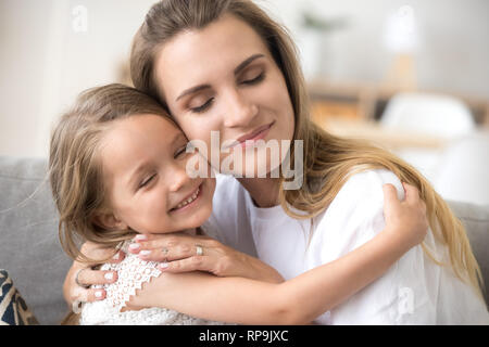 Mère embrassant peu sourire fille montrant l'amour Banque D'Images