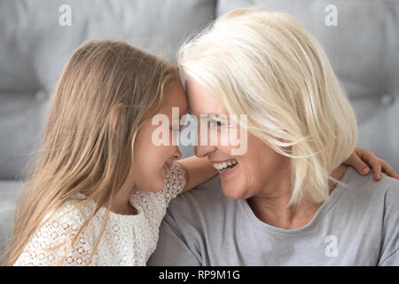 Heureux grand-mère et petite-fille enlacés, toucher leur front Banque D'Images