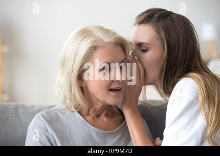 Le partage de femme secret avec surprise de mère, chuchotant dans l'oreille Banque D'Images