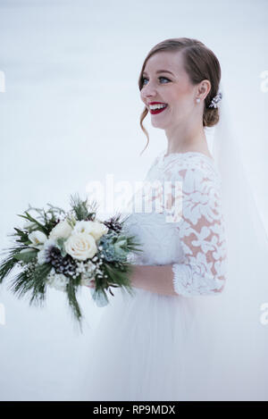 Dans blonde bride holding bouquet robe de mariage Banque D'Images