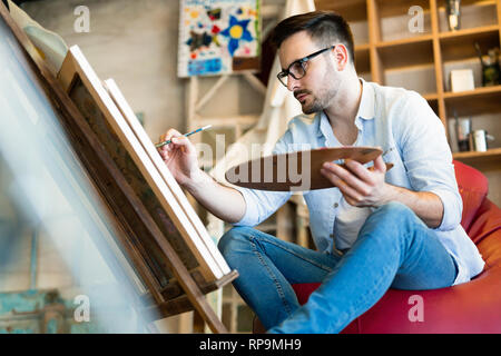 L'école d'art peinture artiste masculin avec de l'huile sur toile Banque D'Images