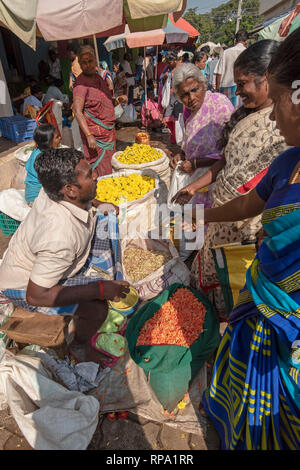 Un acheteur de fleurs la remise de l'argent au vendeur pour une transaction à l'animation animation de Madurai marché aux fleurs. Banque D'Images