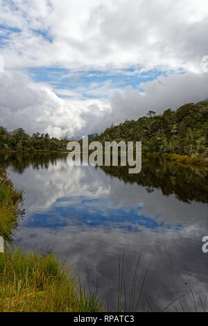 Beaux nuages bleus reflète dans l'eau d'un petit lac dans la région de Lewis Pass Banque D'Images