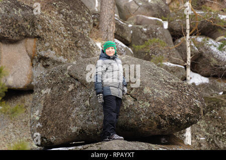 Le garçon monta sur un rocher au milieu des rochers. Journée d'hiver. Réserver Stolby, Krasnoïarsk, en Sibérie, en Russie. Banque D'Images