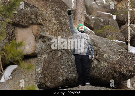 Le garçon monta sur un rocher au milieu des rochers. Journée d'hiver. Réserver Stolby, Krasnoïarsk, en Sibérie, en Russie. Banque D'Images