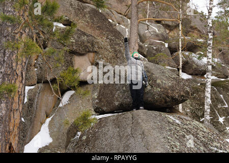 Le garçon monta sur un rocher au milieu des rochers. Journée d'hiver. Réserver Stolby, Krasnoïarsk, en Sibérie, en Russie. Banque D'Images