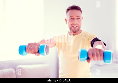 Beau barbu faisant des exercices du matin à la maison avant de se rendre au travail Banque D'Images