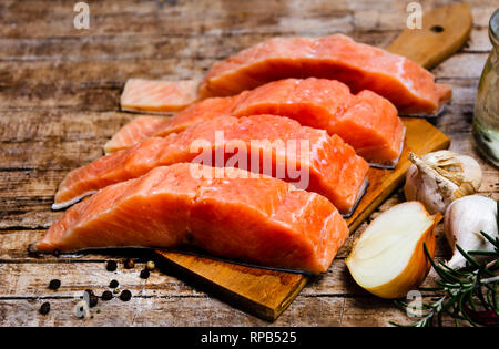 La chair de poisson Saumon avec des ingrédients sur une planche à découper Banque D'Images