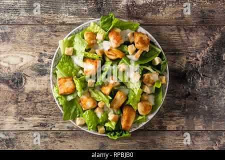 Caesar salade de laitue, poulet et de croûtons sur table en bois. Vue d'en haut. Banque D'Images