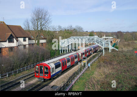 Une ligne centrale train formé de métro de Londres 1992 s'écarte de stock Ambérieu-bois avec une station service en direction ouest. Banque D'Images